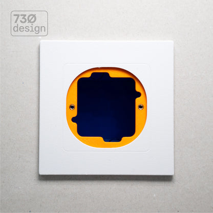 ControlFix NA 2-Gang adapter plate in Arctic White - front view before panel installation, showing orange mounting plate through cutout. Compatible with Dynalite Revolution Display (PDRDE), Revolution Button EU (PDRxE), and Dynalite Antumbra EU panels