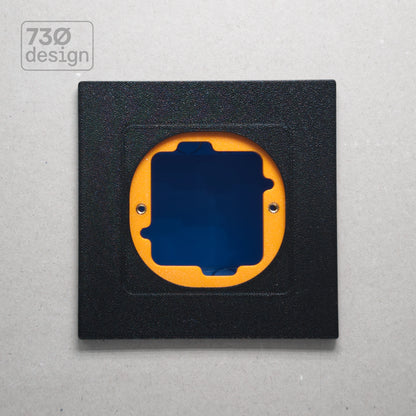 ControlFix NA 2-Gang adapter plate in Obsidian Black - front view before panel installation, showing orange mounting plate through cutout. Compatible with Dynalite Revolution Display (PDRDE), Revolution Button EU (PDRxE), and Dynalite Antumbra EU panels